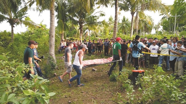 Policemen (left) escorting funeral parlour employees carrying the body of the second of the two Abu Sayyaf militants killed in an encounter with troops in Calape town, Bohol province, central Philippines.