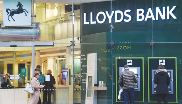 Customers use ATMs at a branch of Lloyds Bank in London. The Treasury made a profit of u00a3894mn ($1.2bn) on its original u00a320.3bn-investment after disposing of its final 0.25% in Lloyds over recent days, the bank said in a statement yesterday.