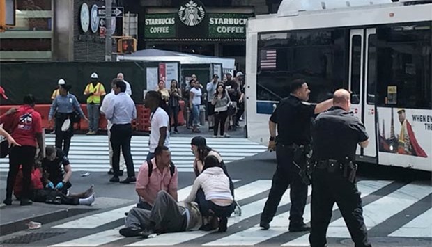 First responders are at the scene as people help the injured after a vehicle struck pedestrians on a sidewalk in Times Square in New York on Thursday.
