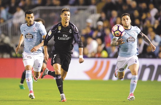 Real Madridu2019s Cristiano Ronaldo (centre) runs past Celta Vigou2019s Gustavo Cabral (left) and Hugo Mallo during the La Liga match at Balaidos Stadium in Vigo, Spain. (Reuters)