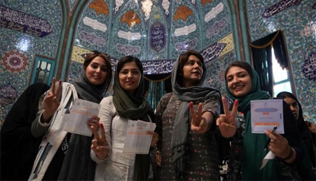 Iranian women show their ink-stained fingers after casting their votes during the presidential election in Tehran on Friday.