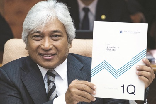 Malaysiau2019s central bank governor Muhammad Ibrahim shows a copy of a report showing the Q1 GDP growth results at the Bank Negara office in Kuala Lumpur.