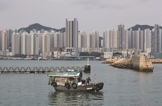 A boat sails in front of private and public housing blocks in Hong Kong. Hong Kongu2019s real estate is among the most expensive in the world and latest government data showed property prices in March surpassed a peak hit in September 2015 amid increasing volumes.