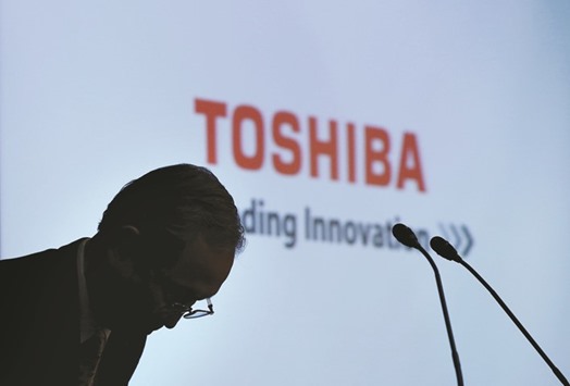 Toshiba CEO Satoshi Tsunakawa bows at the start of a news conference at the companyu2019s headquarters in Tokyo. Toshiba, which values its chip unit at least u00a52tn ($18bn), was forced to put its prized asset on the block this year, after dramatic cost overruns at its now-bankrupt US nuclear unit left it scrambling for cash.