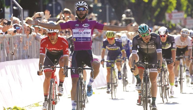 Colombian Fernando Gaviria, of the Quick Step team, celebrates as he crosses the finish line to win the 13th stage of the 100th Giro du2019Italia cycling race in Tortona, Italy. (AFP)
