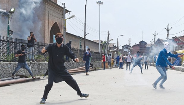 Kashmiri protesters throw stones towards government forces during clashes in Srinagar yesterday.