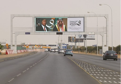 US President Donald Trumpu2019s and Saudi Arabiau2019s King Salmanu2019s photos are seen with flags of both countries on Airport Road as part of celebrations to welcome the US president, in Riyadh, yesterday.