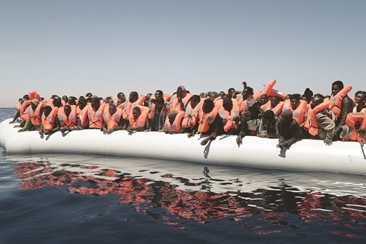 A plastic raft overcrowded with migrants is seen drifting during a search and rescue operation by rescue ship Aquarius, operated by SOS Mediterranean and Doctors without Borders (MSF), in the central Mediterranean.