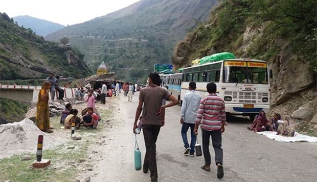 Indian travellers and motorists gather after a landslide blocked their route on the outskirts of Vishuprayag in Uttarakhand state on Friday.