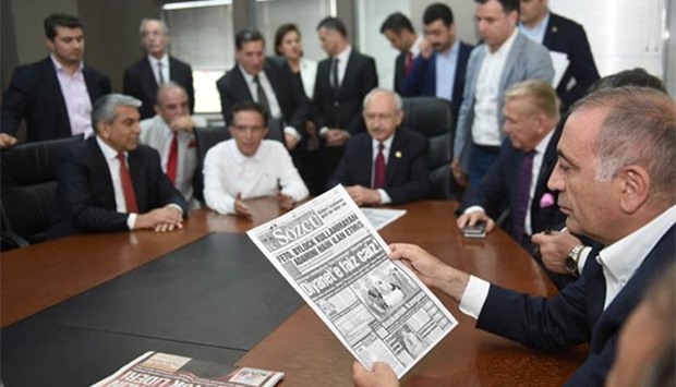 Gursel Tekin, a lawmaker from the main opposition Republican People's Party (CHP) holds a print copy of Sozcu daily as they visit the publication's headquarters in Istanbul on Friday.