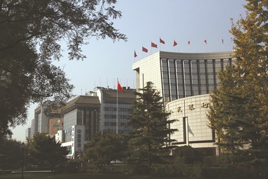 The Peopleu2019s Bank of China headquarters (right) is seen in Beijing. As growth slows in the worldu2019s second-largest economy, the central bank boosted cash injections this week.