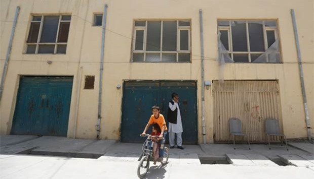 An Afghan boy rides his bicycle in front of a house, where a German aid worker and an Afghan guard were killed, in Kabul on Sunday.