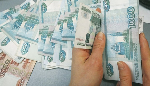 An employee counts rouble banknotes at a shop in Krasnoyarsk, Russia. Encouraging investment by championing the benefits of a stronger currency is among the few options Russia has to push up growth and make up ground lost during its longest recession this century.