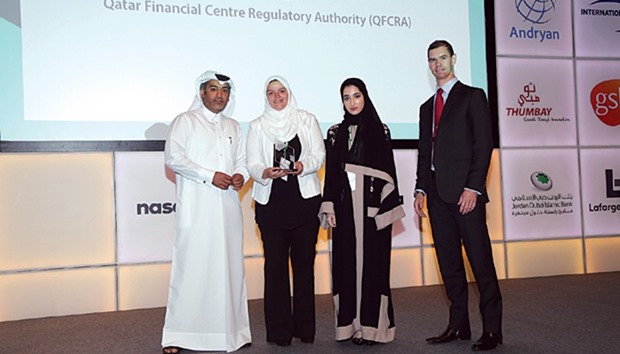 From left: Abdulla; Najat El Mahdy, head of Organisational Development; and Wadha al-Jaber, associate, Human Resources; u2014 all from the QFCRA  u2014 receiving the award from Nicholas Watson, managing director, Naseba Group.