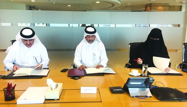 Al-Mahmoud (left), Abdulla (centre) and al-Buenain sign the agreement