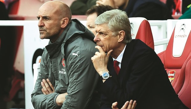 Arsenalu2019s manager Arsene Wenger (right) and his assistant Steve Bould watch their team's match against Everton in London on Sunday. (AFP)