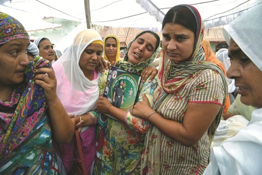 Paramjeet Kaur, the wife of slain soldier Paramjeet Singh, is supported by relatives as she cries during his funeral at Vein Pein village, some 45km from Amritsar yesterday.