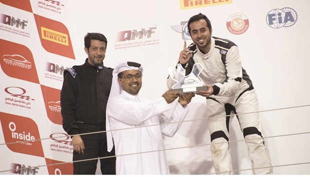 Qataru2019s Abdullah al-Khelaifi (right) receives the trophy from QMMF President Abdulrahman al-Mannai after winning the Qatar Touring Car Championship title at the Losail International Circuit.
