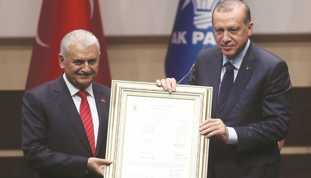Erdogan and Prime Minister Yildirim hold the signed membership document making the president officially an AKP member again, during a special ceremony at the headquarters of the ruling party in Ankara.