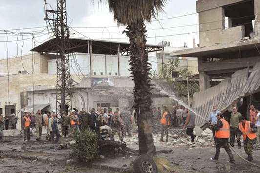 Men put off a fire after an explosion in the Al-Zahraa neighbourhood of Homs city.