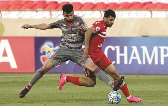 Lekhwiyau2019s Ahmed Yasser (left) vies for the ball with Persepolisu2019 Mehdi Taremi during the Asian Champions League match at the Azadi Stadium in Tehran yesterday. (AFP)