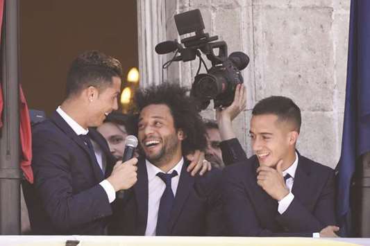 (From left) Real Madridu2019s Cristiano Ronaldo, Marcelo and Lucas Vazquez greet supporters at the Madrid Community headquarters on Monday, a day after the club won their first La Liga title in five years. (AFP)