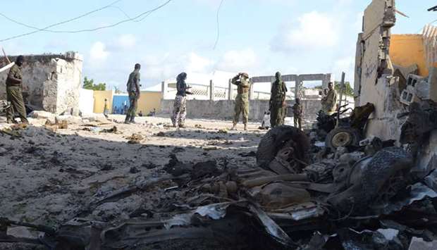 Somali soldiers stand next to the attack site