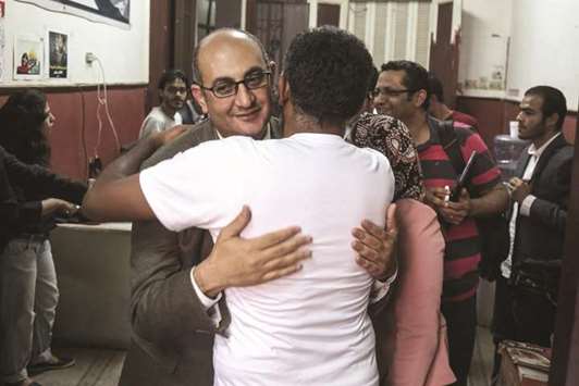 Former Egyptian presidential candidate and rights lawyer Khaled Ali embraces a colleague upon his arrival at his political partyu2019s headquarters in downtown Cairo yesterday, after he was released on bail.