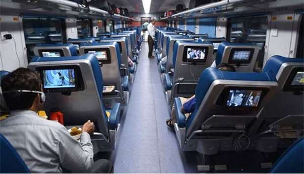 Indian passengers travel onboard the Tejas Express luxury train during its first journey between Mumbai and Goa.