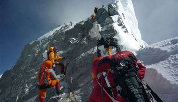 Mountaineers walk past the Hillary Step while pushing for the summit of Mount Everest as they climb the south face of the mountain from Nepal.
