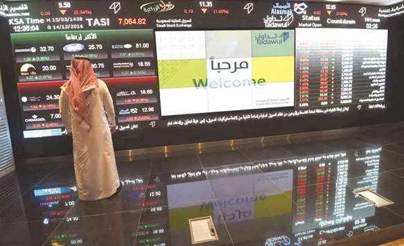 A Saudi investor monitors share prices at the Saudi Stock Exchange, or Tadawul (file). Saudi Arabiau2019s index fell 0.4% yesterday, after briefly trading in positive territory earlier.