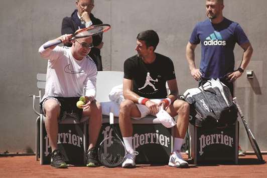 Novak Djokovic (right) of Serbia and his coach Andre Agassi confer during a training session ahead of the French Open at Roland Garros in Paris yesterday. (Reuters)