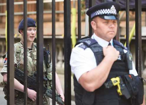 A British army soldier and a police officer secure an entrance to Downing Street in central London.