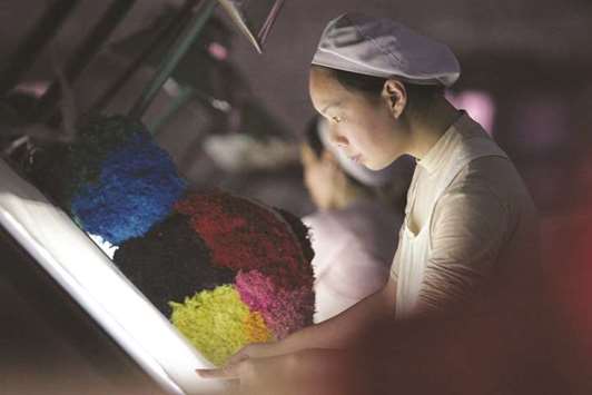 A woman works at a textile factory in Xiangfan, Hubei province. The manufacturing sector in China is losing a tailwind from rising producer price inflation, which helped fuel strong industrial profits but is now coming off from more than five year highs.