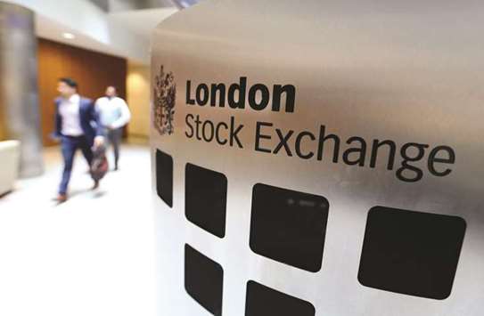 Visitors pass a sign inside the London Stock Exchange Group headquarters. The FTSE 100 index rose 0.4% to close at 7,547.63 points.