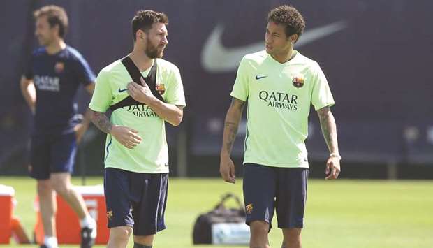 Barcelonau2019s Lionel Messi and Neymar speak during training.