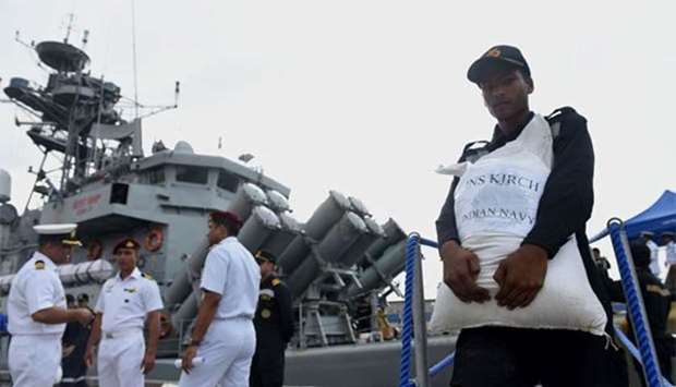 Indian Navy troops offload emergency supplies from the ship Kirch at Colombo harbour on Saturday. Indian medical teams and emergency relief arrived in Sri Lanka on Saturday as the monsoon-related death toll reached 100 and authorities warned of more flooding in low-lying areas.