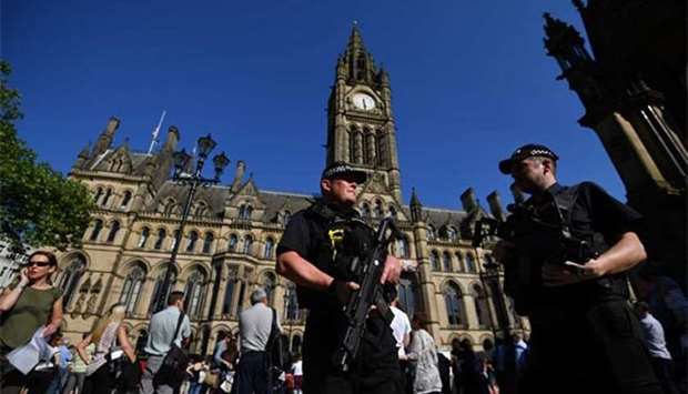 Armed police stand guard in front of the Town Hall in Albert Square, Manchester.