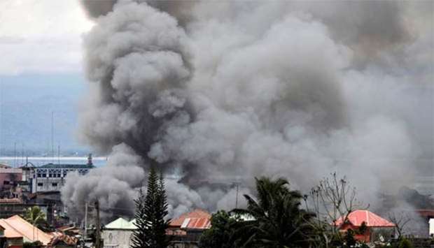 Smoke rises in a residential neighbourhood as fighting rages between the government soldiers and Maute militants in Marawi on Saturday.