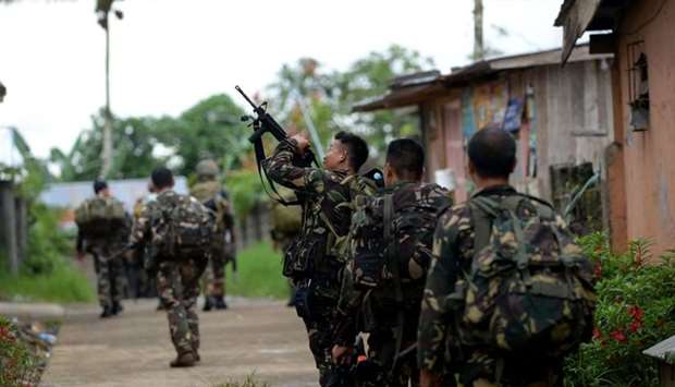 Philippine soldiers patrol a deserted neighbourhood