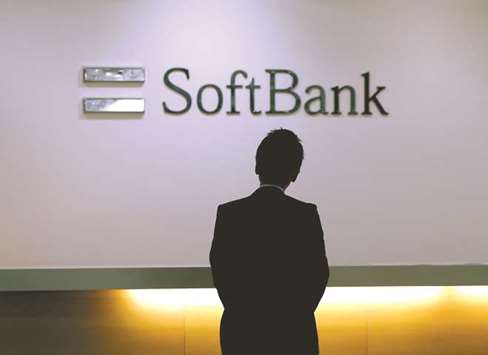 A man looks at the logo of SoftBank Group at the companyu2019s headquarters in Tokyo. SoftBanku2019s chief executive officer Masayoshi Son is working to become the worldu2019s most prolific technology investor, and closed the first round of capital commitments for his Vision Fund this month.