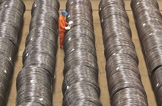 A worker checks steel wires at a warehouse in Dalian, Liaoning province. Liabilities of industrial firms in China rose 6.7% year-on-year as of end-April, according to the statistics bureau.