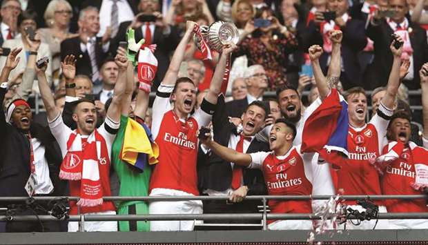 Arsenal players are ecstatic as they celebrate with the trophy after beating Chelsea to win the FA Cup at the Wembley Stadium in London yesterday. (Reuters)