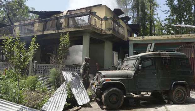 An army vehicle is parked next to a burning house where two Kashmiri rebels were killed during a gunfight in the Tral area south of Srinagar yesterday.