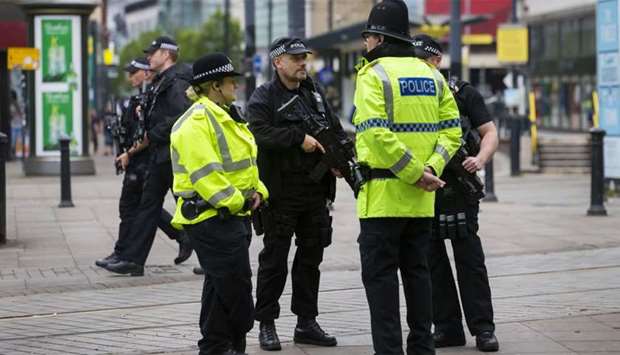 Armed police stand guard near the start of the Great Manchester Run