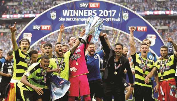 Huddersfield Town manager David Wagner and players celebrate with the trophy.