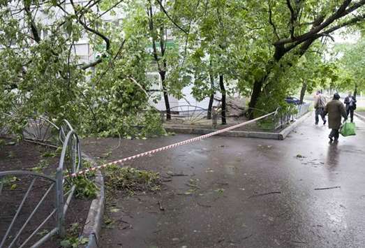 A barrier tape blocks the way near broken trees following a heavy storm in Moscow.