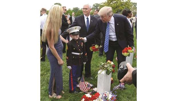 President Donald Trump and Vice President Mike Pence greet young Christian Jacob, whose US Marine father Christopher was killed in a training accident and his mother Brittany, during a visit to Section 60 at Arlington National Cemetery.