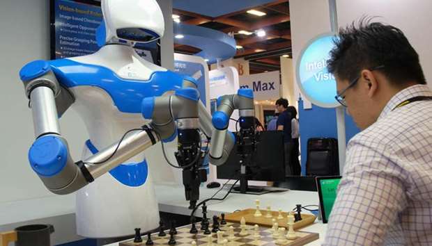 A visitor plays chess with a robot designed by Taiwan\'s ITRI during the Computex Show