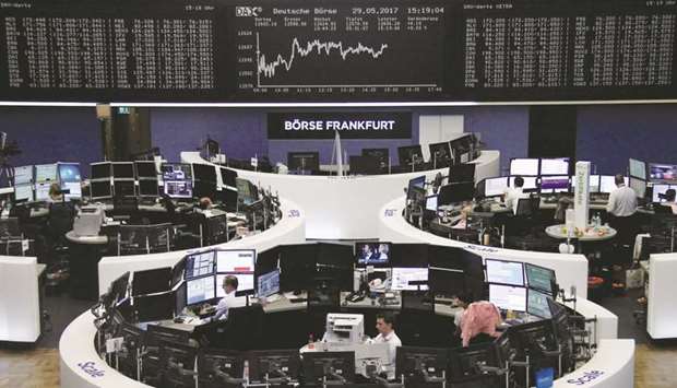 Traders work in front of the German share price index, DAX board, at the stock exchange in Frankfurt. The benchmark Dax 30 was up 0.2% to 12,628.95 points at close yesterday.